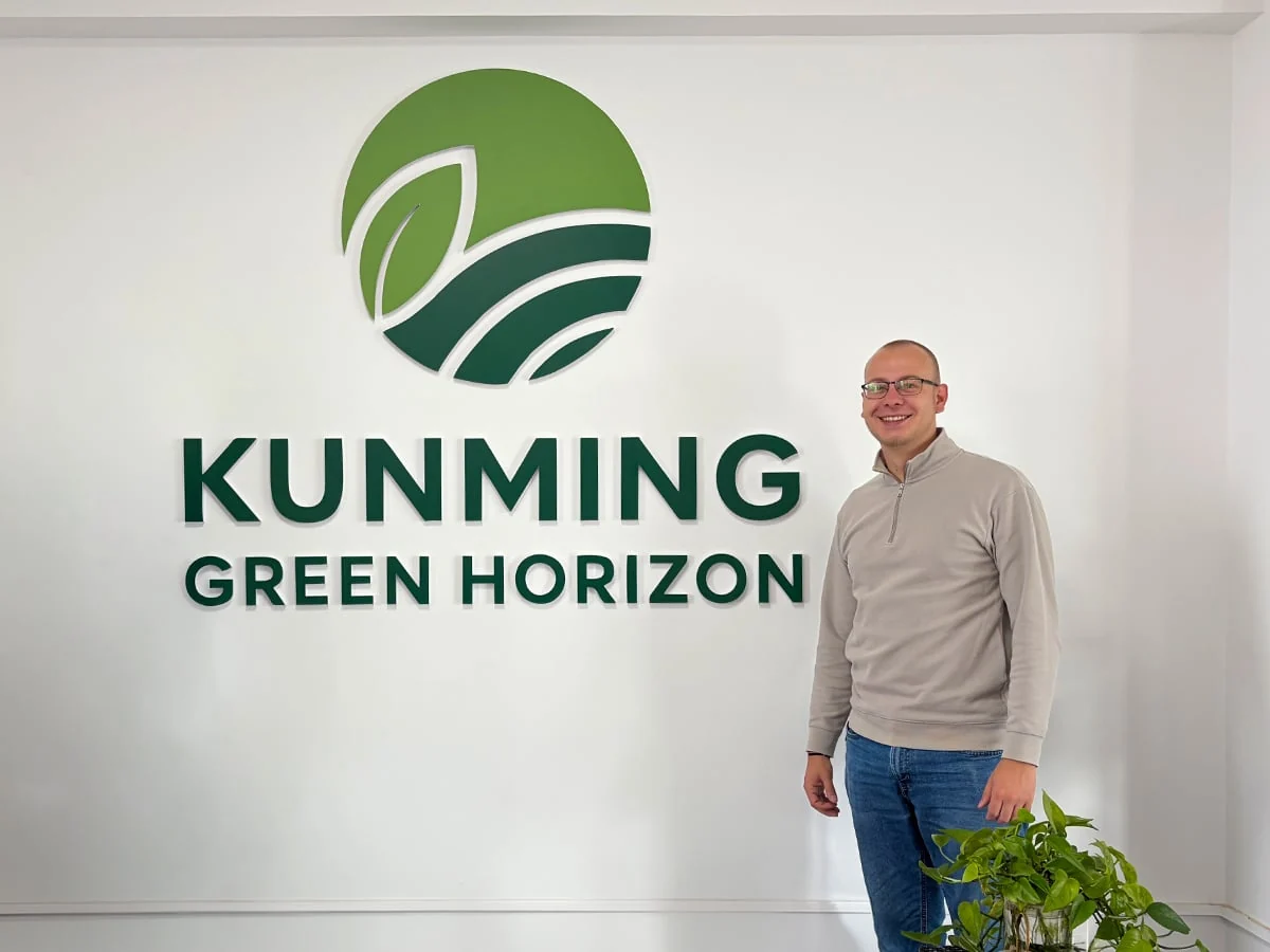 Lars Schalkers beside the Kunming Green Horizon office logo